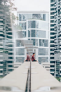 man sitting on white building edge at daytime thumbnail