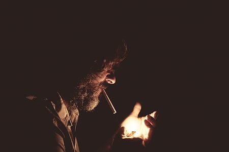 man holding lighter inside dark room thumbnail