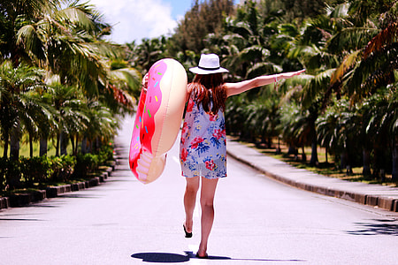 woman in blue and pink sleeveless dress holding buoy during daytime thumbnail