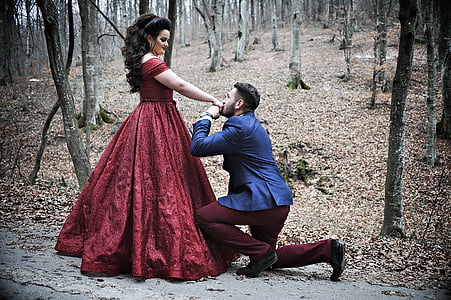 man wears blue suit and women's red dress in the forest thumbnail