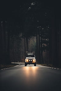 white car driving on car with headlight turned on thumbnail