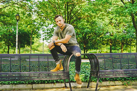 man sitting on black steel bench thumbnail