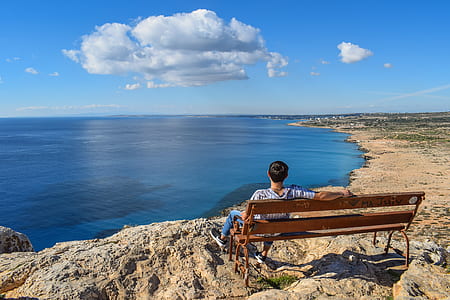 man sitting on bench front of the sea at daytime thumbnail
