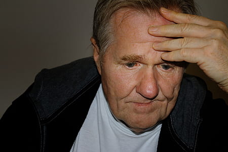 man leaning his forehead against his left hand thumbnail