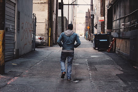 man walking on empty alley at daytime thumbnail