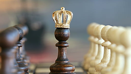 selective focus photography of chess poon with gold-colored crown thumbnail