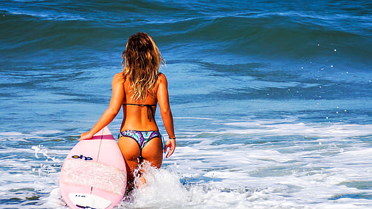 woman wears bikini holds surfboard at daytime in sea thumbnail