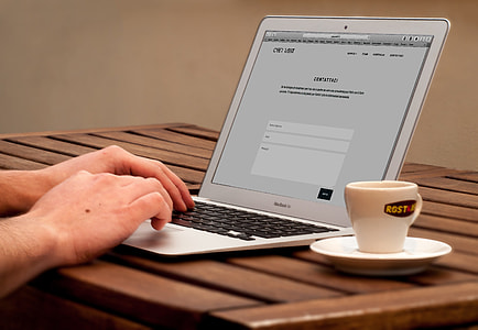 person using MacBook Air while having coffee thumbnail