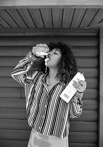 woman drinking milk beside wall thumbnail