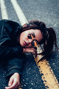 woman posing lying on gray pavment thumbnail