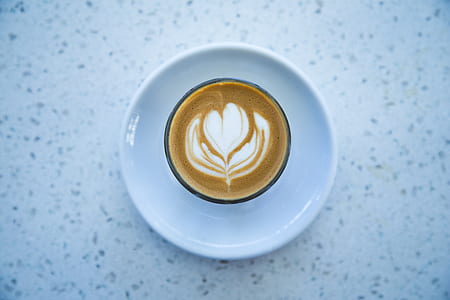 cafe latte on cup with white ceramic saucer thumbnail
