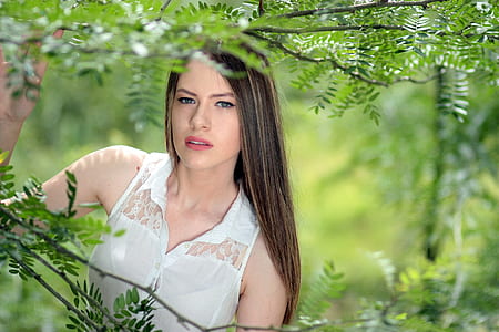woman wearing white lace button-up sleeveless top under shade of tree thumbnail