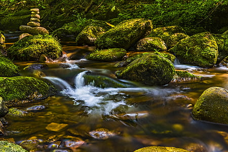 body of water with rocks during daytime photography thumbnail