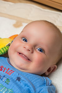 smiling baby lying on bed thumbnail