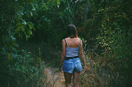 woman walking on forest surrounded by trees thumbnail