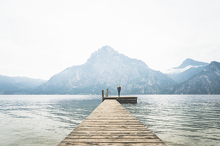 Woman Standing Alone on a Large Wooden Pier on a Lake thumbnail