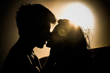 Silhouettes of Couple Kissing Against Sunset thumbnail