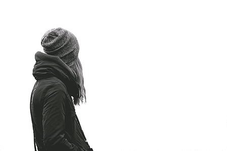 person wearing black jacket with hood and knit cap thumbnail