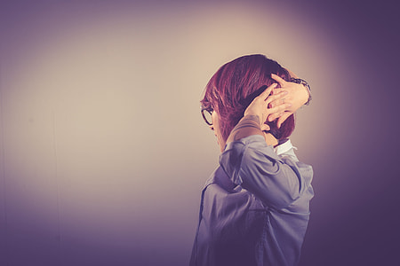 selective focus photography of woman in gray long sleeve top hold her hair thumbnail