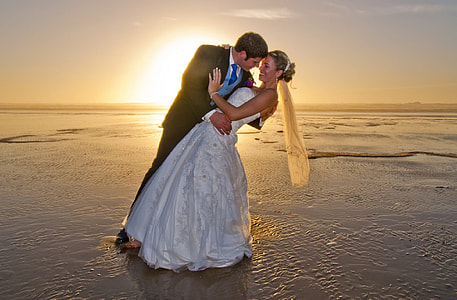 man and woman wearing wedding dresses standing on body of water thumbnail