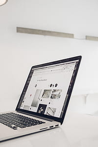 turned on MacBook Pro on white wooden table thumbnail