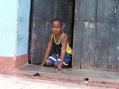 boy kneeling beside slightly opened door thumbnail