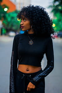 selective focus photography of woman in black long-sleeved shirt and pants standing in middle of street thumbnail
