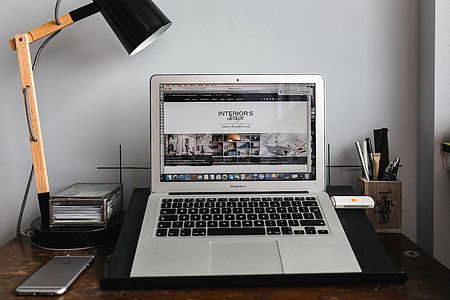 Front view of laptop and mobile phone on the wooden desk thumbnail