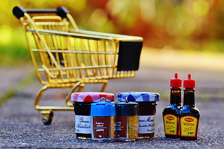assorted-color bottles and jars near yellow shopping cart thumbnail
