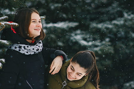 woman leaning on the shoulder of the other woman beside the tree thumbnail