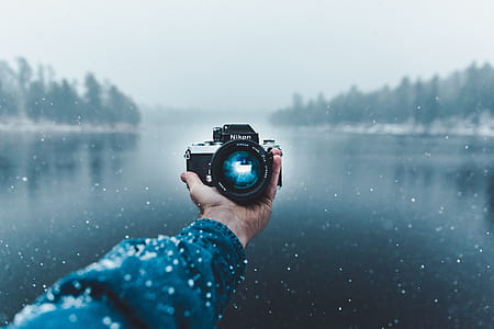 selective focus photography of Nikon camera on person's hand thumbnail