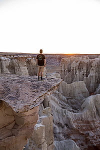 man standing mountain cliff thumbnail
