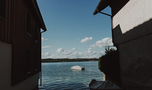 white powerboat near gray house thumbnail