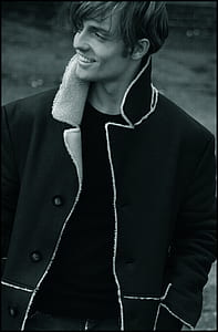 Grayscale Photo Of Man Wearing Black Button-up Notch Lapel Coat Smiling thumbnail