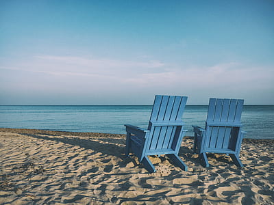 two dock chairs at the beach during day thumbnail