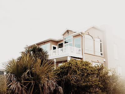 beige and white painted 2-story house with green plants during daytime photography thumbnail