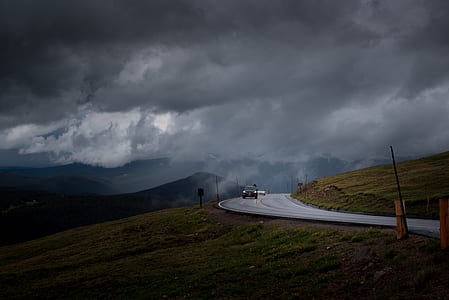 car on asphalt road distance with mountains during daytime thumbnail