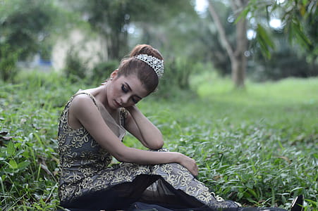 Woman Wearing Brown and White Sleeveless Floral Embroidered Dress Sitting on Green Grass Field thumbnail