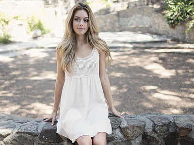 woman wearing white dress sitting on concrete bench thumbnail