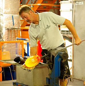 man holding metal rod beside blue metal machine thumbnail