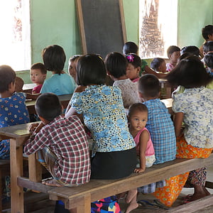 pupils sitting on benches in room thumbnail