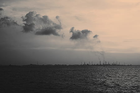 industrial buildings near large body of water thumbnail