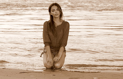 woman kneeling on seashore thumbnail
