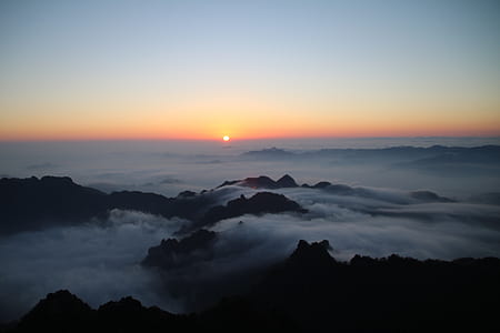 aerial photography of mountain with clouds during golden hour thumbnail