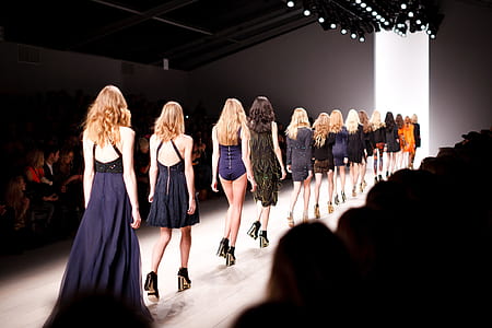 female fashion models walking towards white lit room thumbnail