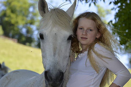 woman in white top standing beside white horse thumbnail