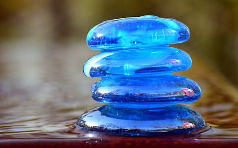 four round blue stones stacks each other place on body of water thumbnail