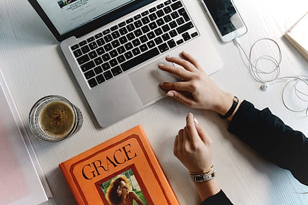 flat lay photo of woman's right hand on top of MacBook Pro thumbnail
