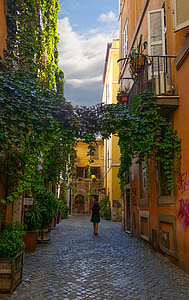 woman walked in hallway between brown buildings thumbnail