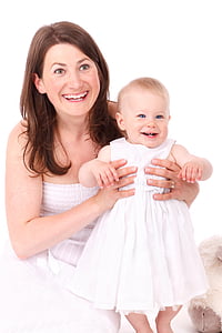 woman wearing white dress carrying baby while smiling photo thumbnail